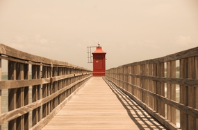 海边木栈道红色灯塔图片